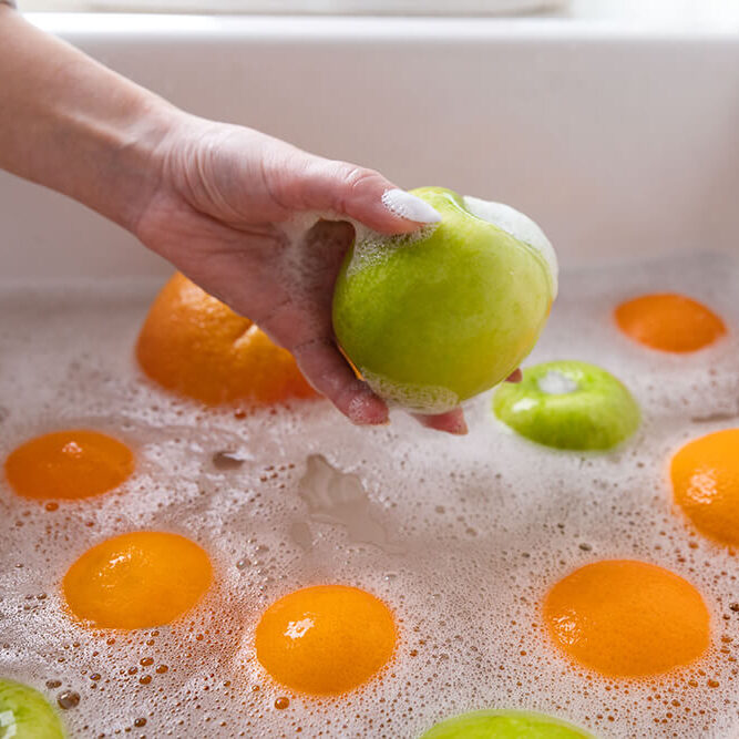 hands-woman-washes-ripe-orange-grapefruit-faucet-sink-kitchen-soapy-water
